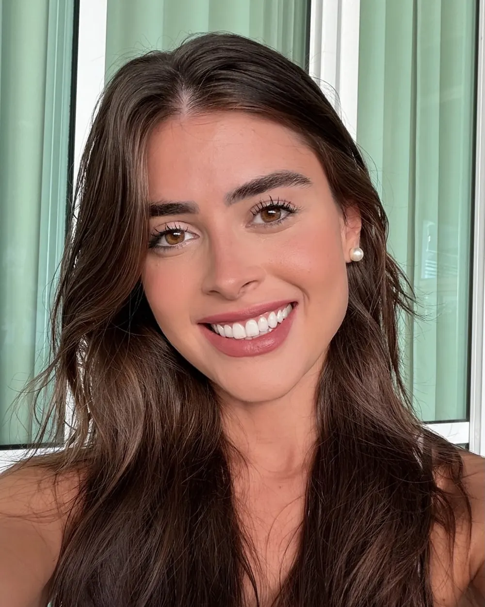 Stephanie sorrindo, de cabelo solto e brinco de pérola